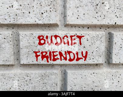 Messaggio economico scritto su un muro di pietra grigia. Simbolo di budget concettuale. Copia spazio. Foto Stock