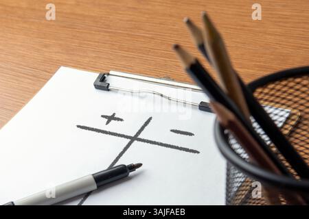 Immagine ravvicinata degli appunti di carta con l'elenco dei pro e dei contro su un tavolo di legno. Valutazione, concetto di confronto. Foto Stock