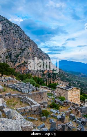 Vista serale panoramica del sito archeologico di Delfi nella Grecia centrale con il tempio di Apollo e il tesoro ateniese Foto Stock