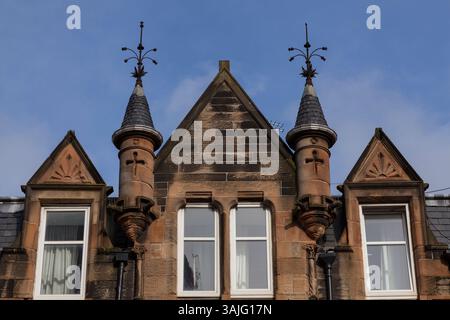 Le distese bionde in arenaria di Broomhill Drive, Glasgow, mostrano i dettagli di alcune delle pietre scolpite e delle torrette durante il sole primaverile Foto Stock