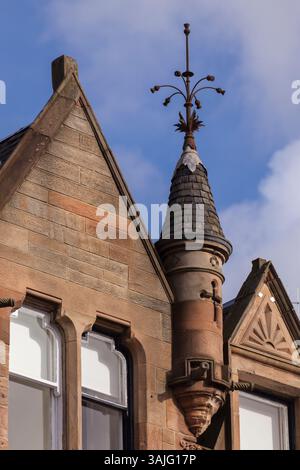 Le distese bionde in arenaria di Broomhill Drive, Glasgow, mostrano i dettagli di alcune delle pietre scolpite e della torretta durante il sole primaverile Foto Stock
