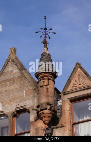 Le distese bionde in arenaria di Broomhill Drive, Glasgow, mostrano i dettagli di alcune delle pietre scolpite e della torretta durante il sole primaverile Foto Stock
