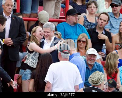 15 agosto 2013 - Calgary, Alberta, Canada - il primo Ministro Stephen Harper, centro, riceve un abbraccio da una ragazza nella folla mentre partecipa al concerto Alberta Flood Aid a Calgary, Alberta, giovedì. (Immagine di credito: © Larry MacDougal via ZUMA Wire) Foto Stock