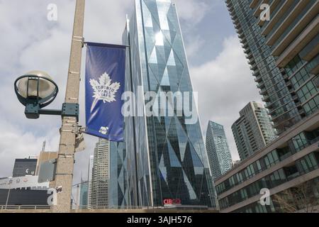 Logo Toronto Maple Leafs su uno striscione appeso all'esterno su Bay Street con una vista scintillante delle torri sud di CIBC Square Foto Stock