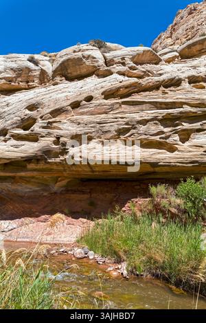 Il fiume Fremont scorre sotto le antiche formazioni rocciose del Capitol Reef National Park nello Utah, USA Foto Stock