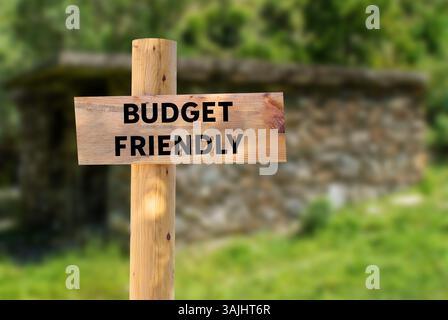 Messaggio economico scritto su un cartello di legno sullo sfondo della natura. Simbolo di budget concettuale. Copia spazio. Foto Stock