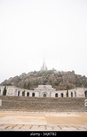 Valle de los Caídos: Una maestosa Croce avvolta nella nebbia in un giorno cupo Foto Stock