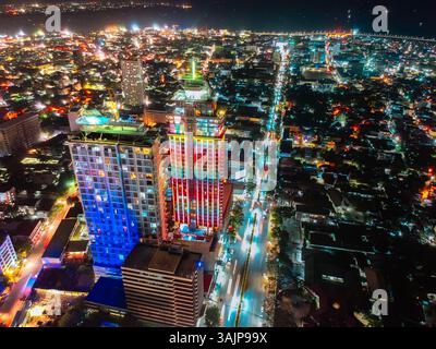 Vibrante paesaggio notturno di Cebu, Filippine, con grattacieli illuminati e strade animate, che mettono in risalto la dinamica vita urbana della città Foto Stock