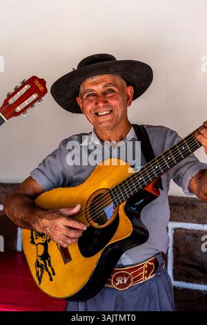 Un tradizionale musicista argentino canta e suona la chitarra per i ristoranti della città di Salta, provincia di Salta, Argentina. Foto Stock