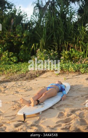 Un rilassante Surfer sulla splendida spiaggia dopo un'incredibile sessione di Surfing che si gode la natura Foto Stock