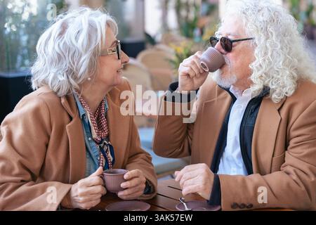 Coppia caucasica senior che parla da vicino mentre beve un caffè al caffè all'aperto Foto Stock