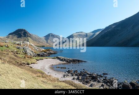 Sulla riva di Wastwater nel Lake District occidentale, guardando verso un gruppo di alcune delle vette più alte d'Inghilterra Foto Stock