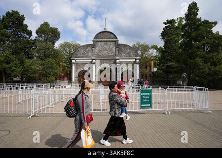 Pechino, Cina. 12 aprile 2025. La gente passa davanti allo zoo di Pechino che è temporaneamente chiuso a causa dei forti venti a Pechino, capitale della Cina, il 12 aprile 2025. Molte parti della Cina settentrionale stanno subendo venti di forza e cadute di temperatura il sabato. Crediti: Ju Huanzong/Xinhua/Alamy Live News Foto Stock