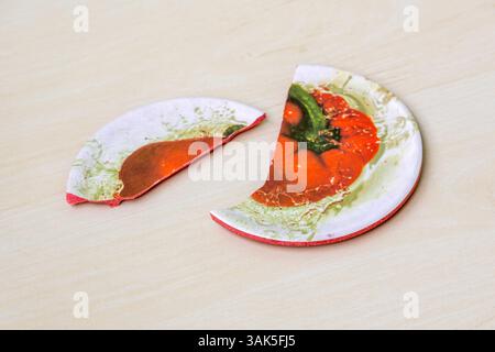 Coperchio in melamina rotto per una tazza o una tazza di caffè/tè, su una superficie di legno. Foto Stock
