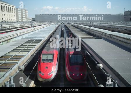 Roma, Italia - 11 aprile 2025: Un treno elettrico rosso ad alta velocità, Frecciarossa di Trenitalia, parcheggio presso un binario della stazione termini di Roma. Foto Stock
