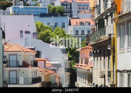 I fitti e colorati edifici del quartiere pena di Lisbona, con tetti rossi e balconi, creano un vivace paesaggio urbano nella storica città vecchia di fram Foto Stock