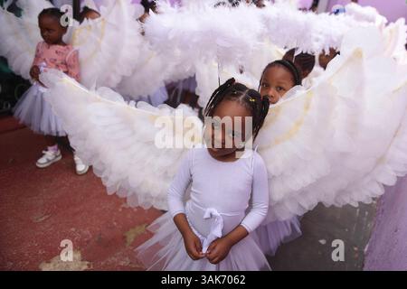 La produzione della passione di Cristo in Sud Africa le ragazze sudafricane si preparano ad esibirsi in una produzione intitolata la sfilata della passione di Cristo, una collaborazione tra la scuola di sviluppo della prima infanzia ECD Kiddies Hope Academy e la Nkosana Ngobese Foundation attraverso le strade di Dobsonville, Soweto, Sud Africa 12 aprile 2025. La passione della produzione di Cristo è una rappresentazione drammatica dell'ultimo giorno della vita di Gesù, culminante nella crocifissione. La produzione presentava bambini di 5 e 6 anni in costumi, vestiti da angeli, Gesù con una croce e soldati romani, oltre a un gigante Foto Stock