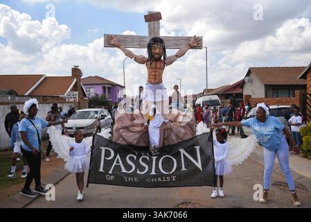 The Passion of the Christ Production in Sud Africa i partecipanti partecipano alla Passion of the Christ Parade, una collaborazione tra la scuola ECD per lo sviluppo della prima infanzia Kiddies Hope Academy e la Nkosana Ngobese Foundation attraverso le strade di Dobsonville, Soweto, Sud Africa 12 aprile 2025. La passione della produzione di Cristo è una rappresentazione drammatica dell'ultimo giorno della vita di Gesù, culminante nella crocifissione. La produzione presentava bambini di 5 e 6 anni in costumi, vestiti da angeli, Gesù che trasportava una croce e soldati romani, oltre a marionette giganti che interpretavano il ruolo di Jesu Foto Stock