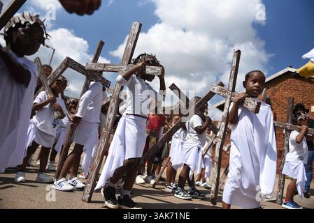 The Passion of the Christ Production in Sud Africa i partecipanti partecipano alla Passion of the Christ Parade, una collaborazione tra la scuola ECD per lo sviluppo della prima infanzia Kiddies Hope Academy e la Nkosana Ngobese Foundation attraverso le strade di Dobsonville, Soweto, Sud Africa 12 aprile 2025. La passione della produzione di Cristo è una rappresentazione drammatica dell'ultimo giorno della vita di Gesù, culminante nella crocifissione. La produzione presentava bambini di 5 e 6 anni in costumi, vestiti da angeli, Gesù che trasportava una croce e soldati romani, oltre a marionette giganti che interpretavano il ruolo di Jesu Foto Stock