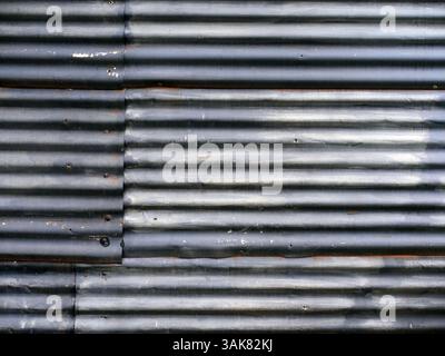 Vecchia parete in lamiera ondulata composta da diversi pezzi Foto Stock