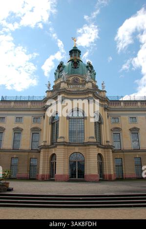 Castello di Charlottenburg a Berlino, Germania, con i suoi giardini barocchi formali e il suggestivo cielo nuvoloso sullo sfondo Foto Stock