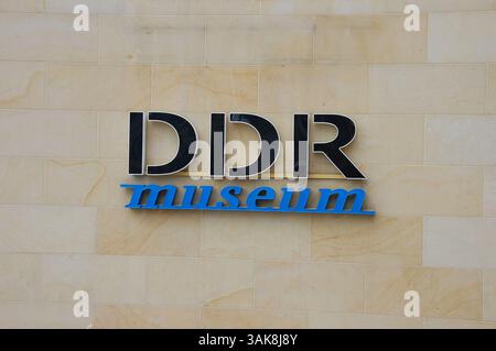 Segno del Museo DDR di Berlino, dedicato alla vita quotidiana nella Germania Est durante l'era della DDR, montato su un muro di pietra beige Foto Stock