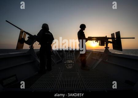 7 luglio 2014 - in mare - i marinai della Marina degli Stati Uniti sono colpiti dal sole del tramonto, mentre le mitragliatrici calibro .50 a bordo della prua dell'incrociatore missilistico guidato classe Ticonderoga USS Vella Gulf 7 luglio 2014 nel Mar Egeo. (Foto di Edward Guttierrez III /US Navy via Planetpix) (immagine di credito: © Mcs3 Edward Guttierrez III/Planet Pix via ZUMA Wire) Foto Stock