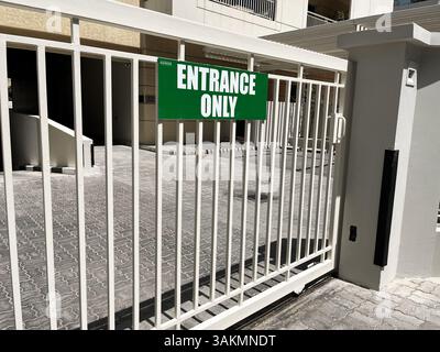 Cancello in metallo con cartello verde ingresso solo all'ingresso del complesso residenziale o commerciale. Dubai UAE, 11 aprile 2025 Foto Stock