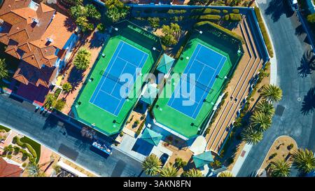 Top Down aereo dei campi da tennis di lusso nell'esclusivo quartiere di Suburban Foto Stock