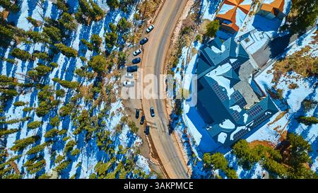 Antenna di un moderno edificio innevato con pannelli solari nel paesaggio montano Foto Stock