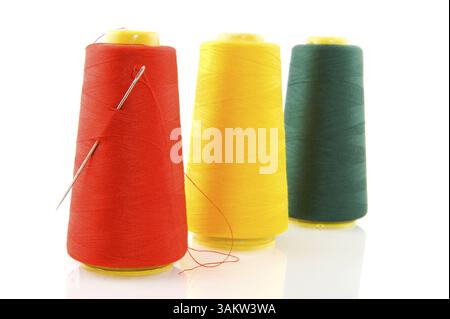Tre bobine con fili colorati in fila Foto Stock