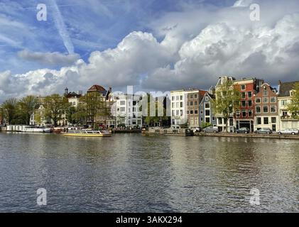 Amsterdam, Paesi Bassi - 2 ottobre 2019: Canale di Amsterdam con tipiche case e case galleggianti olandesi, barche in serata con splendidi riflessi d'acqua Foto Stock