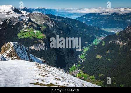 Vista pittoresca con prati verdi e pendii nebbiosi dalla cima della montagna, Mannlichen, Grindelwald, Oberland Bernese, Svizzera, Europa Foto Stock