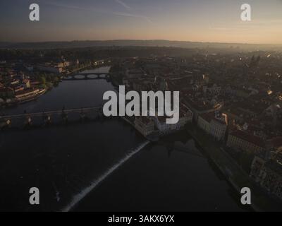 Ripresa aerea di Praga lungo il fiume con ponti sul fiume Moldava, Repubblica Ceca. Vista all'alba Foto Stock