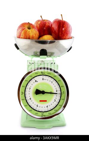 Il peso di mele rosse a un retrò bilancia da cucina Foto Stock