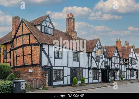Una fila di edifici storici in legno conservati con facciate bianche e nere e finestre con piombo lungo una strada di Amersham. Segnaletica visibile i Foto Stock
