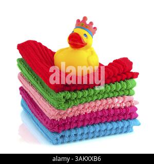 Asciugamani colorati con anatra da bagno isolata su bianco Foto Stock