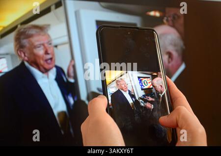 Jiangmen,Guangdong,Cina.13 aprile,2025.i cinesi usano lo smartphone per guardare le notizie sulla Cina e sulle tariffe USA. L'amministrazione del presidente DEGLI STATI UNITI Donald Trump ha esentato smartphone, computer e altri dispositivi elettronici dalle tariffe "reciproche”, tra cui i prelievi del 125 per cento imposti alle importazioni cinesi. Credito: Yurou Guan/Alamy Foto Stock