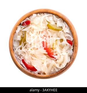 Insalata di Puszta, insalata di cavolo sottaceto in una ciotola di legno. Popolare contorno ungherese, realizzato con cavolo a fette sottili, cetriolini tagliati, peperoni e cipolle. Foto Stock