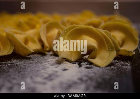 Tortelli fatti a mano su un letto di farina Foto Stock