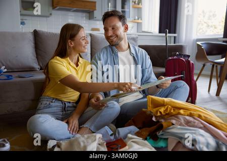 Coppia felice leggendo carta cartina pianificazione vacanza di viaggio Foto Stock