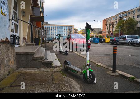Deva, Romania - 11 aprile 2025 scooter elettrico ecologico e comodo mezzo di trasporto paesaggio urbano Foto Stock