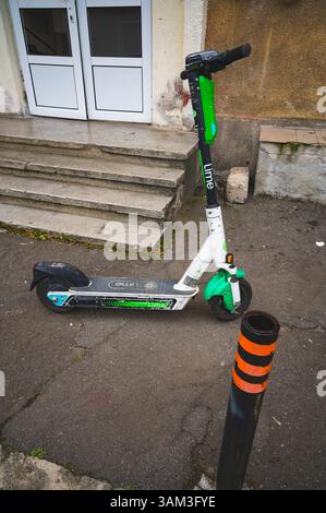 Deva, Romania - 11 aprile 2025 scooter elettrico ecologico e comodo mezzo di trasporto paesaggio urbano Foto Stock