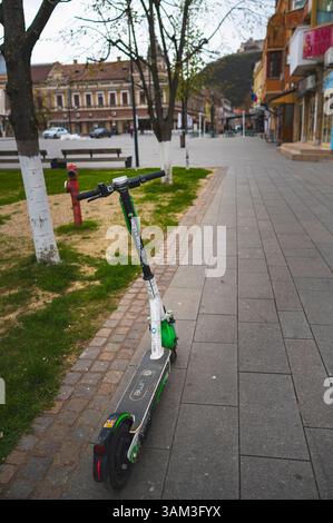 Deva, Romania - 11 aprile 2025 scooter elettrico ecologico e comodo mezzo di trasporto paesaggio urbano Foto Stock