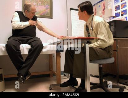 11 marzo 2004 - Stati Uniti - NIENTE MAGS, NIENTE VENDITE -- NOTIZIA KRT USA BLOCCATA: MED-ORGANDONATION KRT FOTOGRAFIA DI STEVE DYKES/SEATTLE TIMES (marzo 29) il paziente renale Bob Hickey mostra al dottor Adolfo Villar il suo braccio durante una visita a Denver, Colorado, centro di dialisi l'11 marzo 2004. (mvw) 2004. (Immagine di credito: © Steve Dykes/mct/ZUMAPRESS.com) Foto Stock