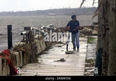26 settembre 2004 - Stati Uniti - NO MAGS, NESSUNA VENDITA FINO AL 10 OTTOBRE 2004 -- KRT US NEWS STORY SLUGGED: WEA-JEANNE KRT FOTOGRAFIA DI PETER ANDREW BOSCH/MIAMI HERALD (settembre 26) FORT PIERCE, FL -- Lionel Sanchez cammina lungo il muro danneggiato del mare a Fort Pierce, Florida, dopo che l'uragano Jeanne ha soffiato attraverso l'area il 26 settembre 2004. (cdm) 2004 (immagine di credito: © Peter Andrew Bosch/mct/ZUMAPRESS.com) Foto Stock