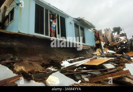 26 settembre 2004 - Stati Uniti - KRT LA NOTIZIA degli Stati Uniti È BLOCCATA: WEA-JEANNE KRT FOTOGRAFIA DI RED HUBER/ORLANDO SENTINEL (MIAMI OUT) (settembre 26) SATELLITE BEACH, FL - Troy Taynton e Barbara Carlsen guardano fuori da casa loro i danni causati dall'ondata di tempesta dall'uragano Jeanne il 26 settembre 2004. L'ondata ha portato via il loro portico in cemento. (cdm) 2004 (immagine di credito: © Orlando Sentinel/mct/ZUMAPRESS.com) Foto Stock