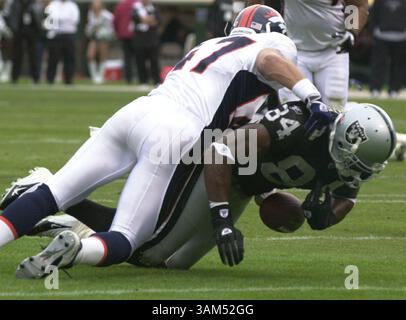 17 ottobre 2004 - U.S. - KRT SPORTS STORY SLUGGED: BRONCOS-RAIDERS KRT PHOTOGRAPH BY EDDIE LEDESMA/CONTRA COSTA TIMES (17 ottobre) OAKLAND, CA -- il wide receiver dei Raiders Jerry Porter fumò la palla mentre fu placcato da John Lynch dei Broncos nel secondo quarto della loro partita al Network Associates Coliseum di Oakland, California, domenica 17 ottobre 2004. (Mvw) 2004 (immagine di credito: © Eddie Ledesma/mct/ZUMAPRESS.com) Foto Stock