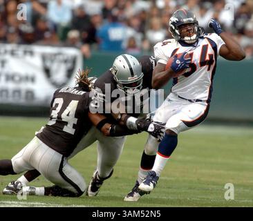 17 ottobre 2004 - Stati Uniti - KRT SPORTS STORY SLUGGED: BRONCOS-RAIDERS KRT PHOTOGRAPHY DI DAN HONDA/CONTRA COSTA TIMES (17 ottobre) OAKLAND, CA -- OAKLAND's Ray Buchanan, Left, e Danny Clark cercano di fermare i Reuben Droughns di Denver durante la loro partita al Network Associates Coliseum di Oakland, California, domenica 17 ottobre 2004. (Mvw) 2004 (immagine di credito: © Dan Honda/mct/ZUMAPRESS.com) Foto Stock