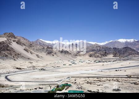 Vista panoramica dell'arido paesaggio della valle dell'Indo e delle montagne innevate, vista dal monastero di Spituk, vicino a Leh in Ladakh, India. Foto Stock